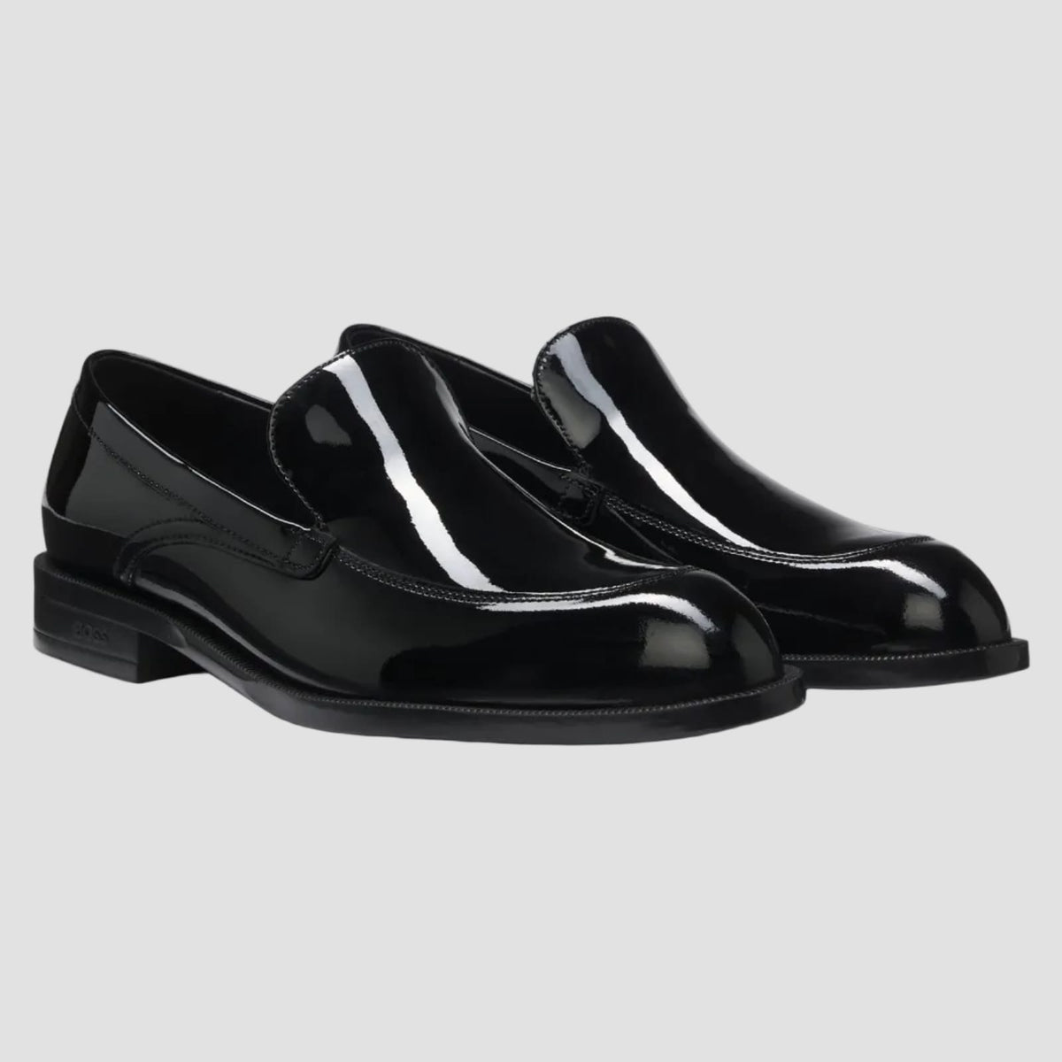 Black slip-on shoe with velcro strap on a white background