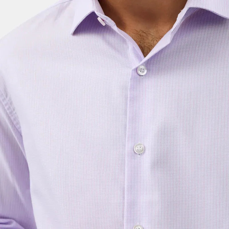 Close-up of a man wearing a light lavender long-sleeve button-down dress shirt with a subtle micro-check pattern and white buttons.
