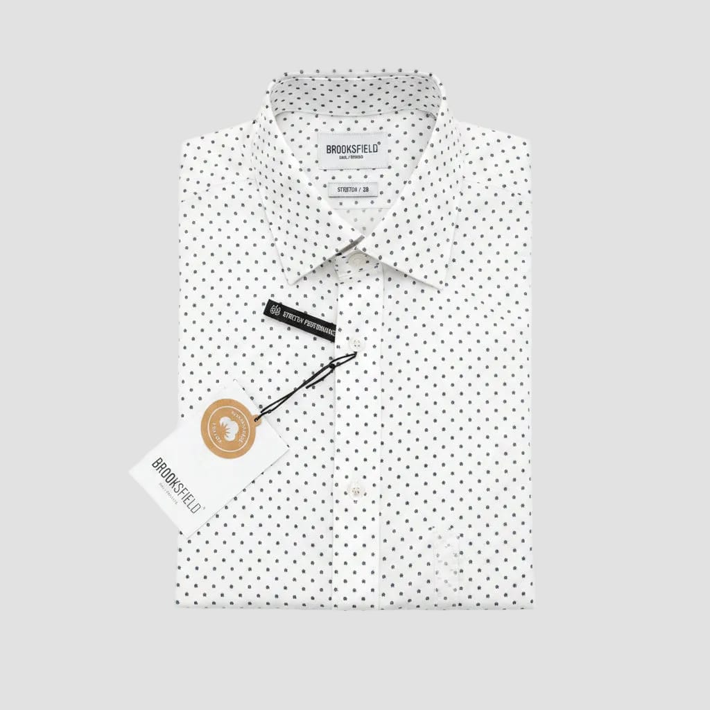 White shirt with black polka dots and 'Brooksfield' branding on a gray surface.