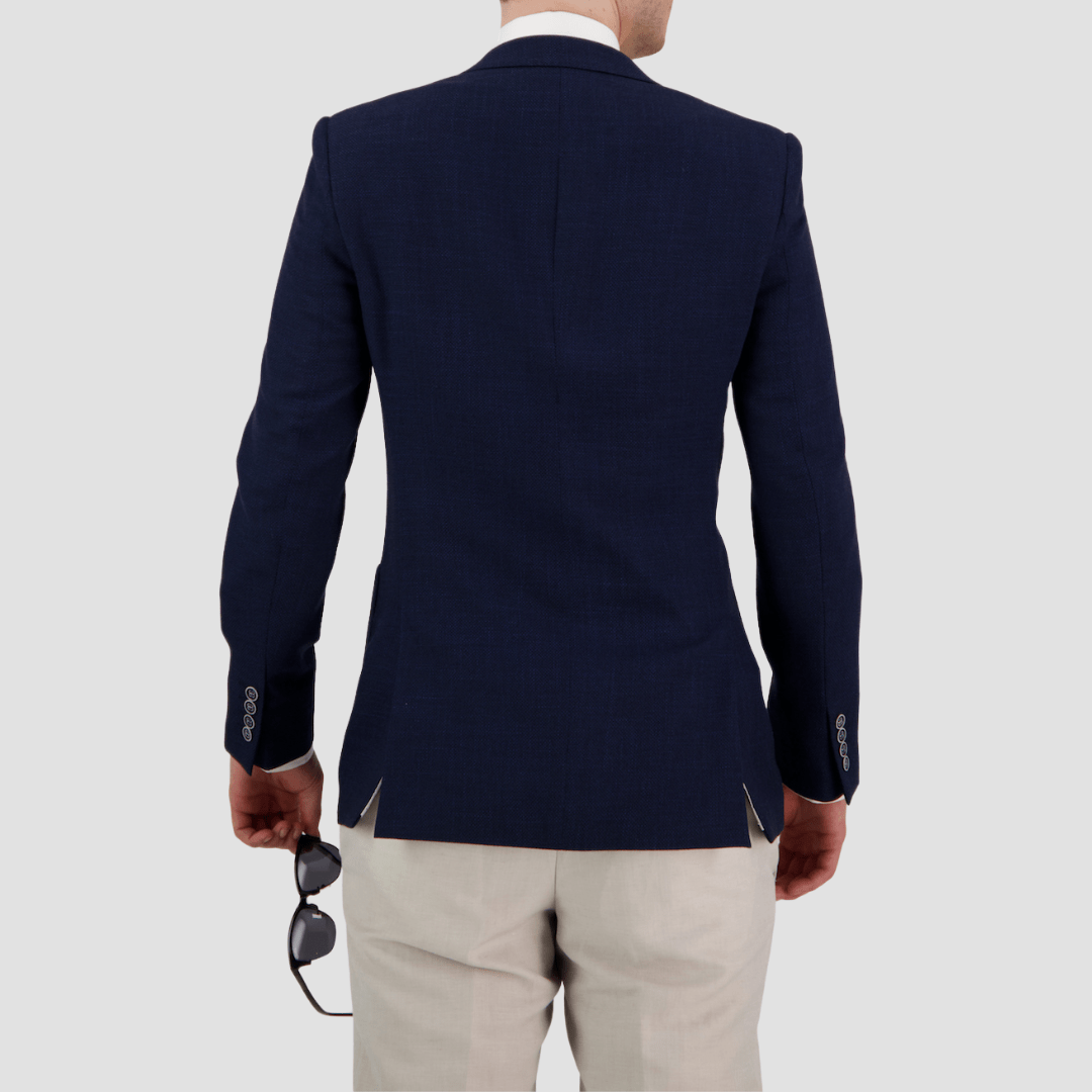 A tailored fit navy sports jacket with notch lapel, two button front, patch pockets, and four button sleeve by Bruton.
