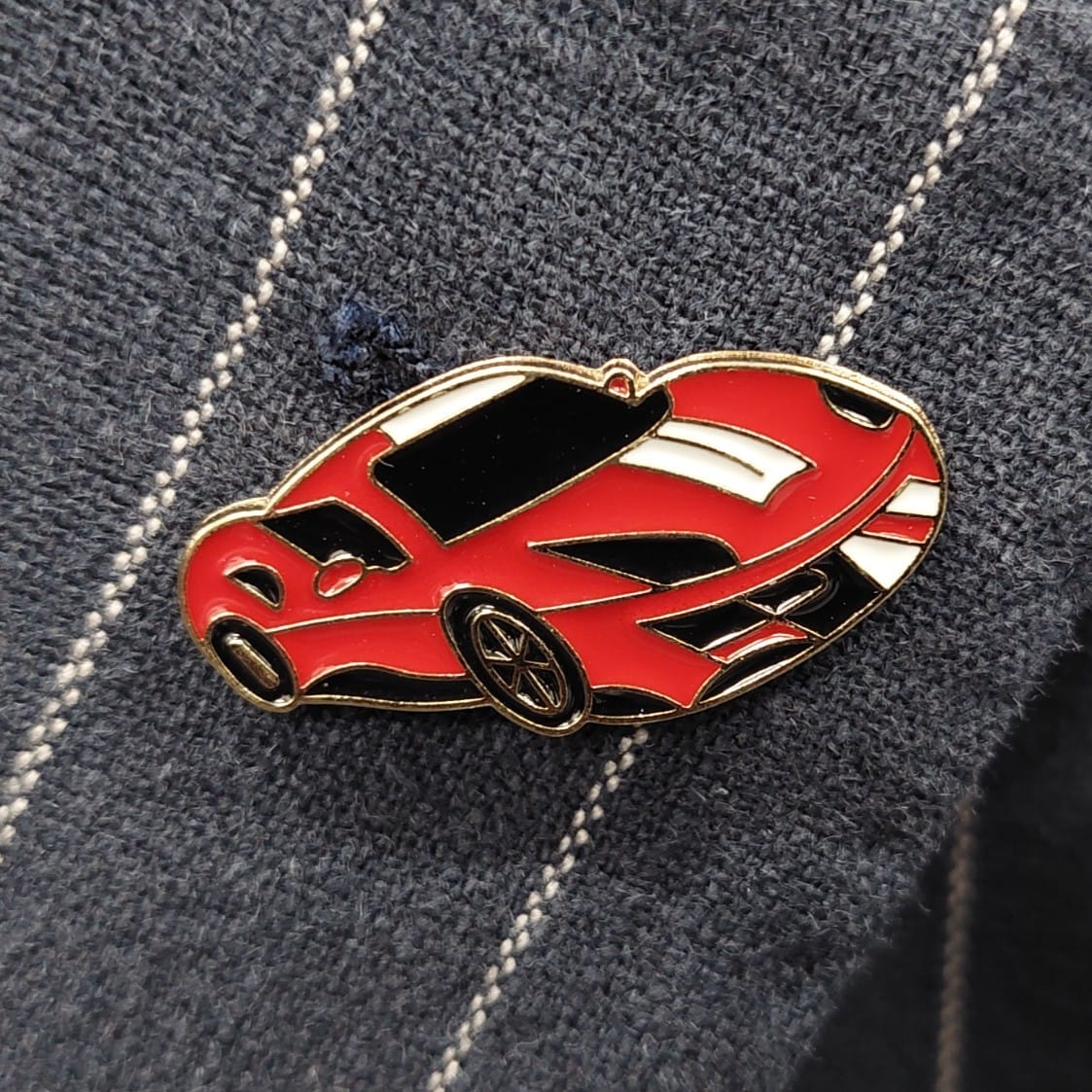 Genoa navy pinstripe sports jacket with notch lapel, patch pockets and rear vents. Red Sportscar Pin.