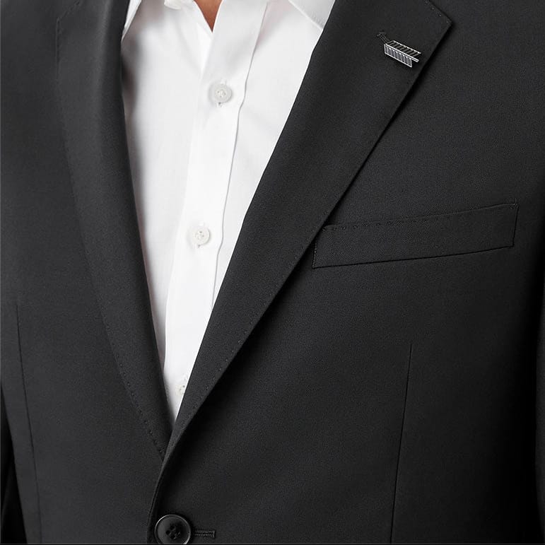 Close-up of a man wearing a black suit jacket over a white button-down shirt, cropped from the lower face to the chest against a plain white background.