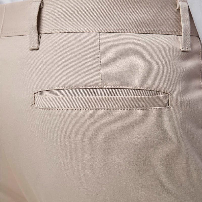 Close-up of the back waistband and pocket area of stone trousers, showing belt loops, stitching, and a welt pocket.