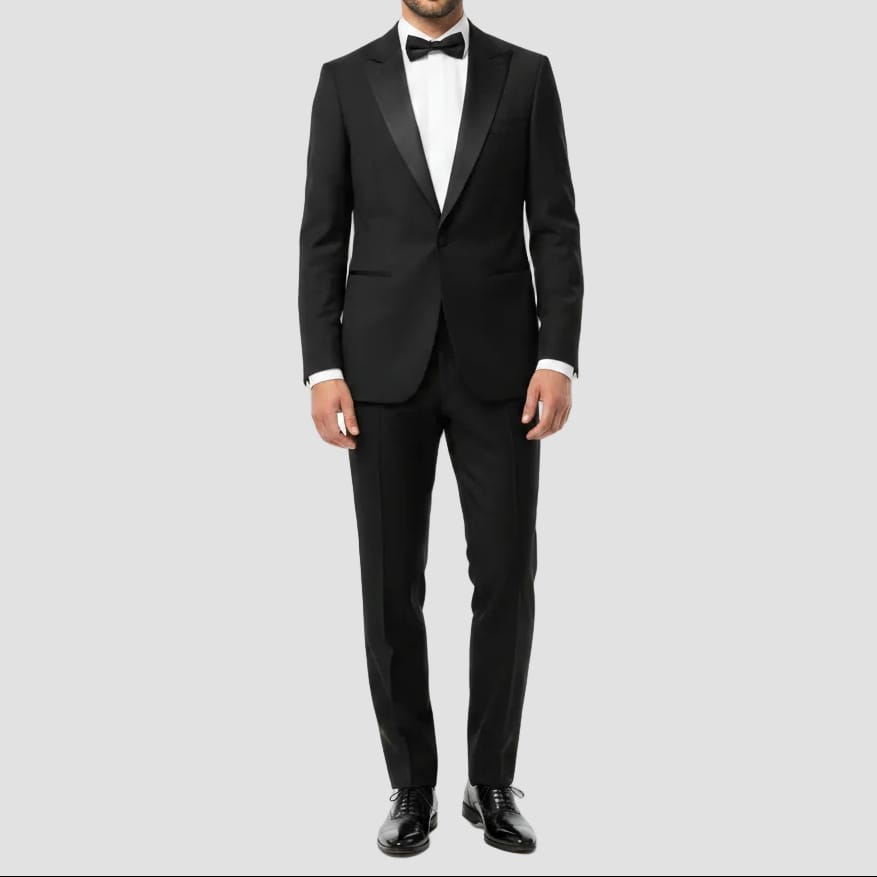 Black tuxedo jacket on a hanger against a neutral background