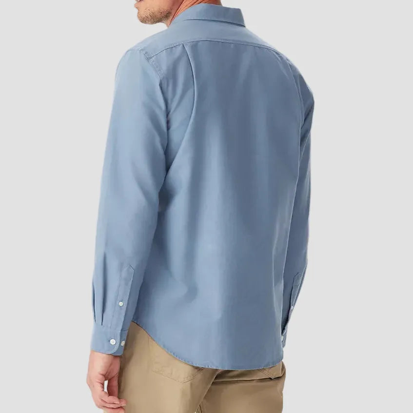 Man wearing a light blue shirt and beige pants on a white background