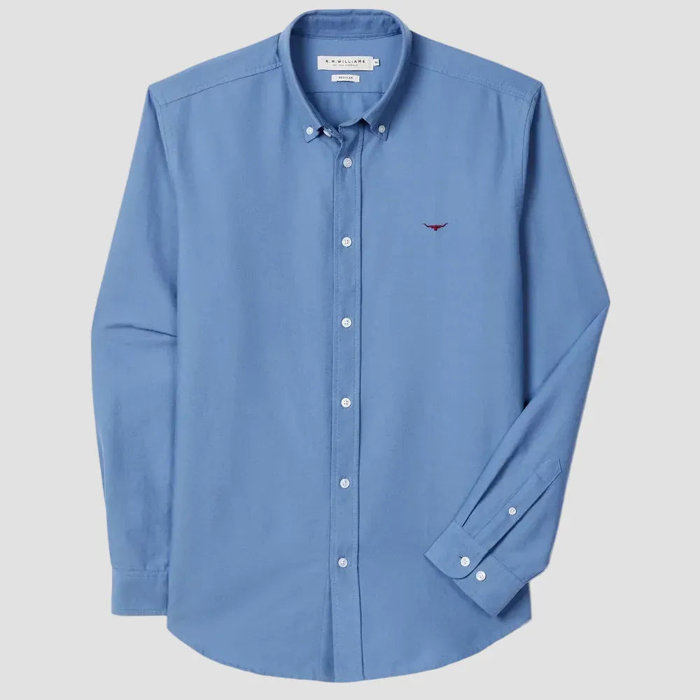 Blue button-up shirt with a small logo on a light gray background