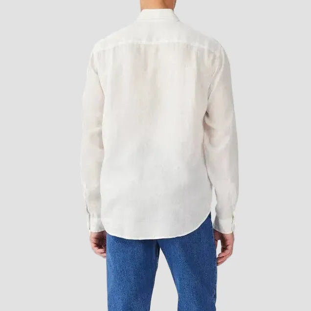 Person wearing a white button-up shirt and blue jeans on a white background