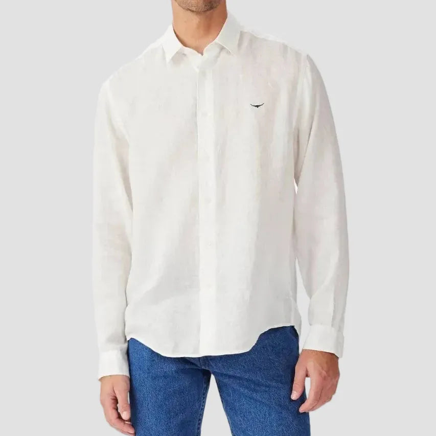 Man wearing a white button-up shirt with a small logo on a white background