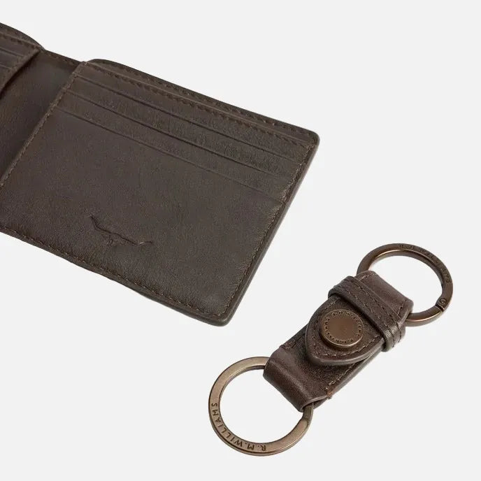 A dark brown leather bi-fold wallet shown open next to a matching brown leather keychain with metal key rings, on a clean white background.