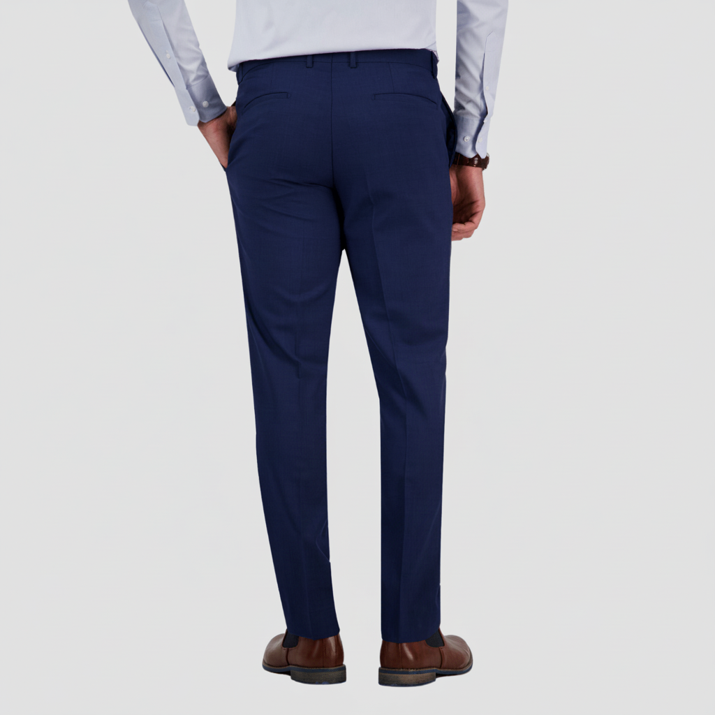 A man wearing a demin-blue suit trouser by Savile Row with a white shirt and brown shoes.