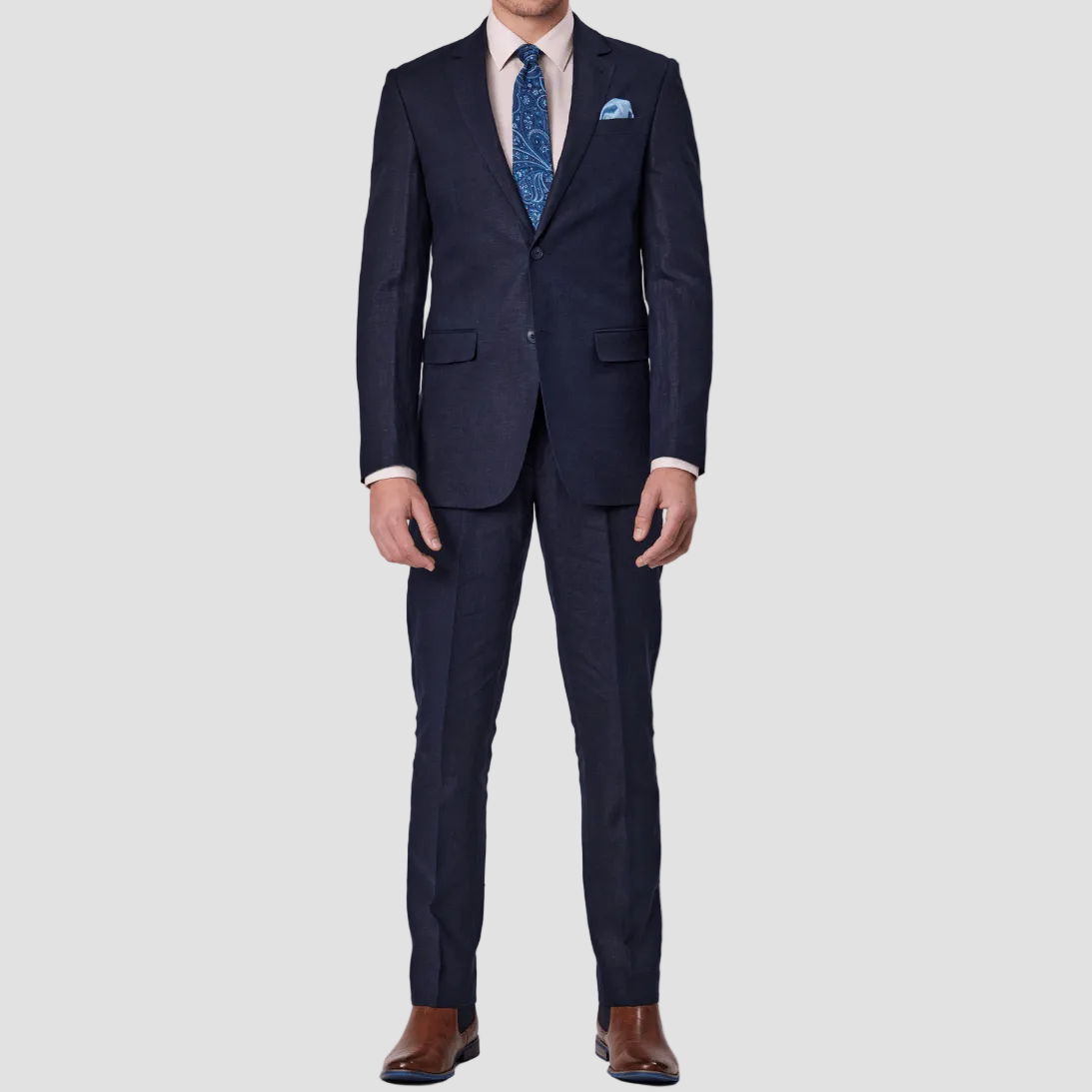Mens pure linen navy suit by Savile Row with a blue tie and pocket square and brown leather shoes. 