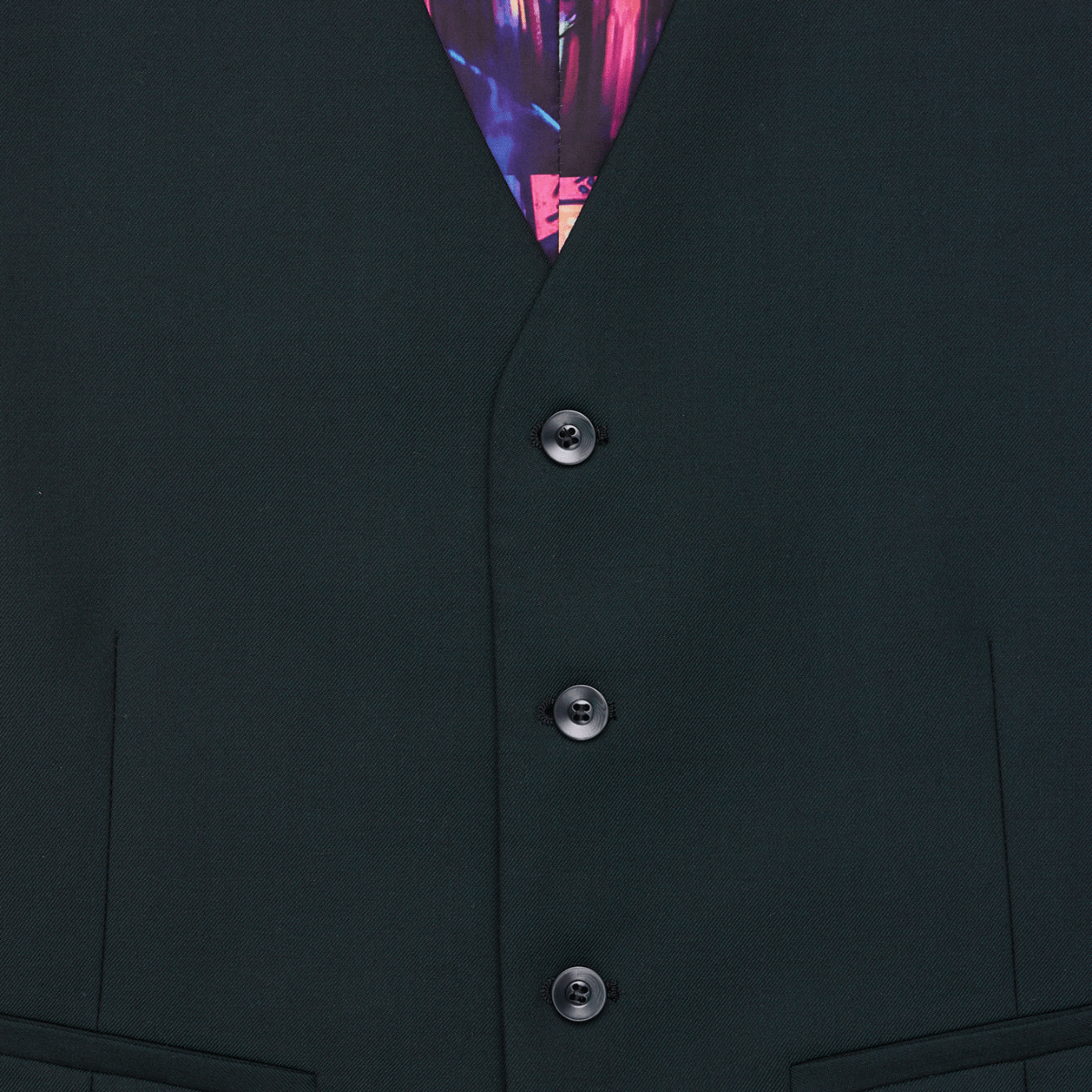 Close up of a tailored fit men's suit vest by Savile Row, in forest green wool with a four button front and satin back with an adjustable tab. 
