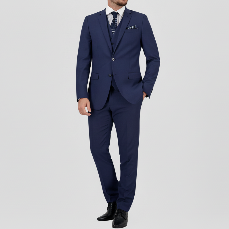 A man wearing a blue two-piece Savile Row suit with a notch lapel, white shirt, pocket square and tie.
