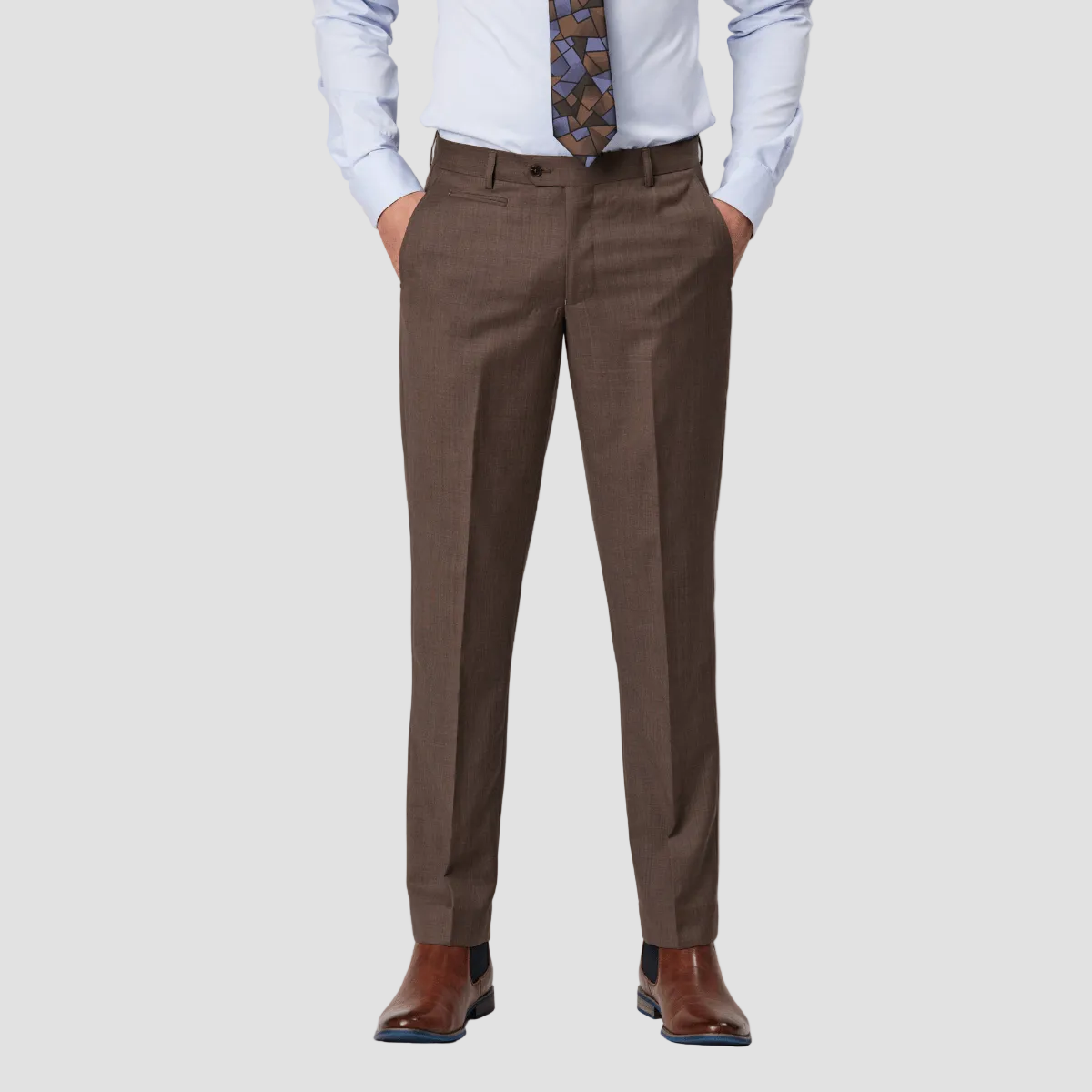 A man wearing a brown pure merino wool suit trouser by Savile Row, with a white shirt and a tie.
