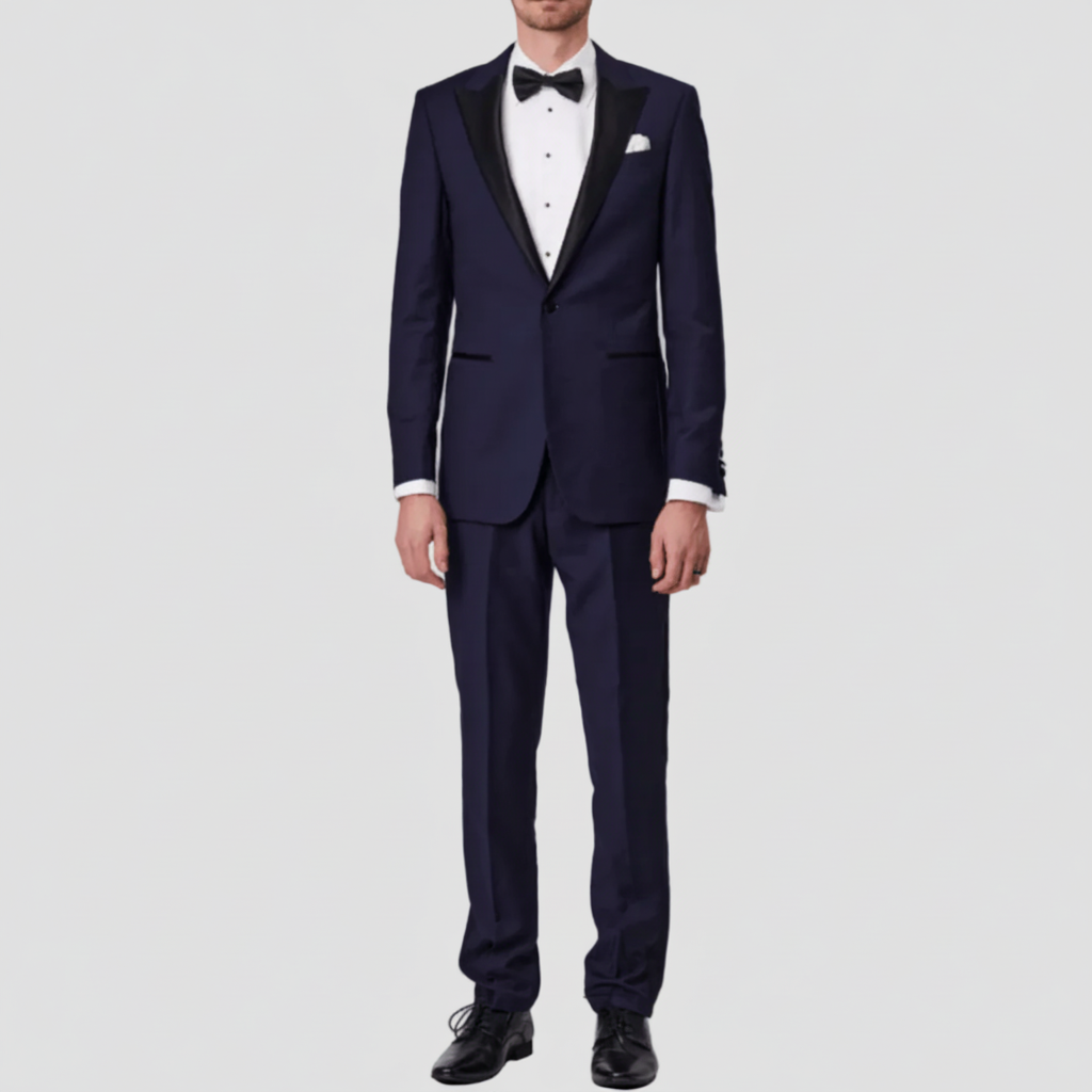 Navy Australian merino wool suit by Savile Row with a white shirt, black bow tie, white pocket square and black leather shoes.