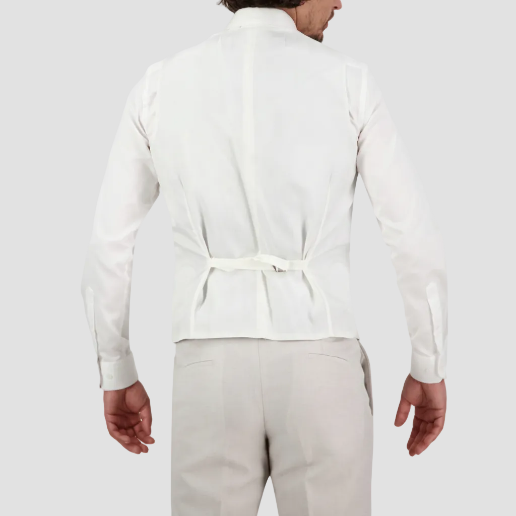 A man wearing a salt Savile Row tailored fit waistcoat with a four button front and satin back with an adjustable tab, paired with a white shirt.