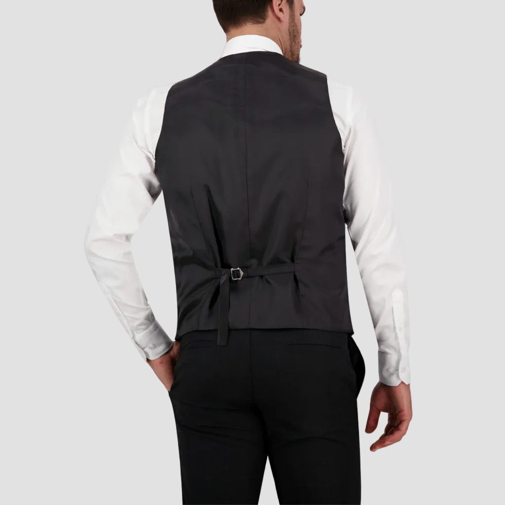 Man wearing a black vest over a white shirt 