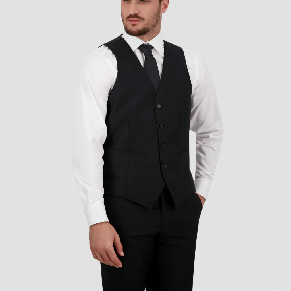 A man wearing a tailored fit black vest with a four-button front, paired with a white shirt and a tie.