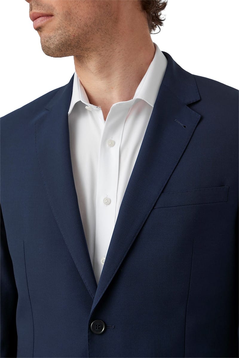Navy suit jacket over a white shirt on a plain background