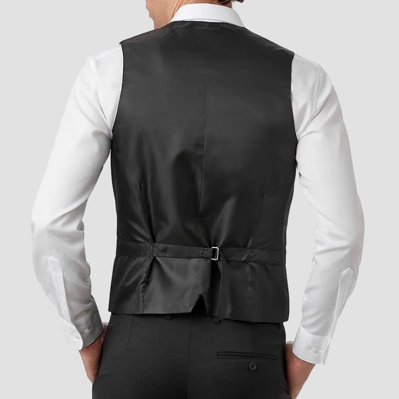 Man wearing a black vest over a white shirt on a white background