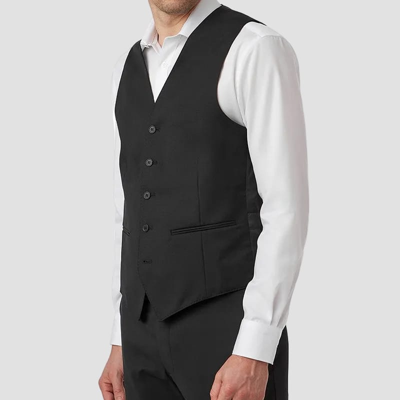Man wearing a black vest over a white shirt on a white background
