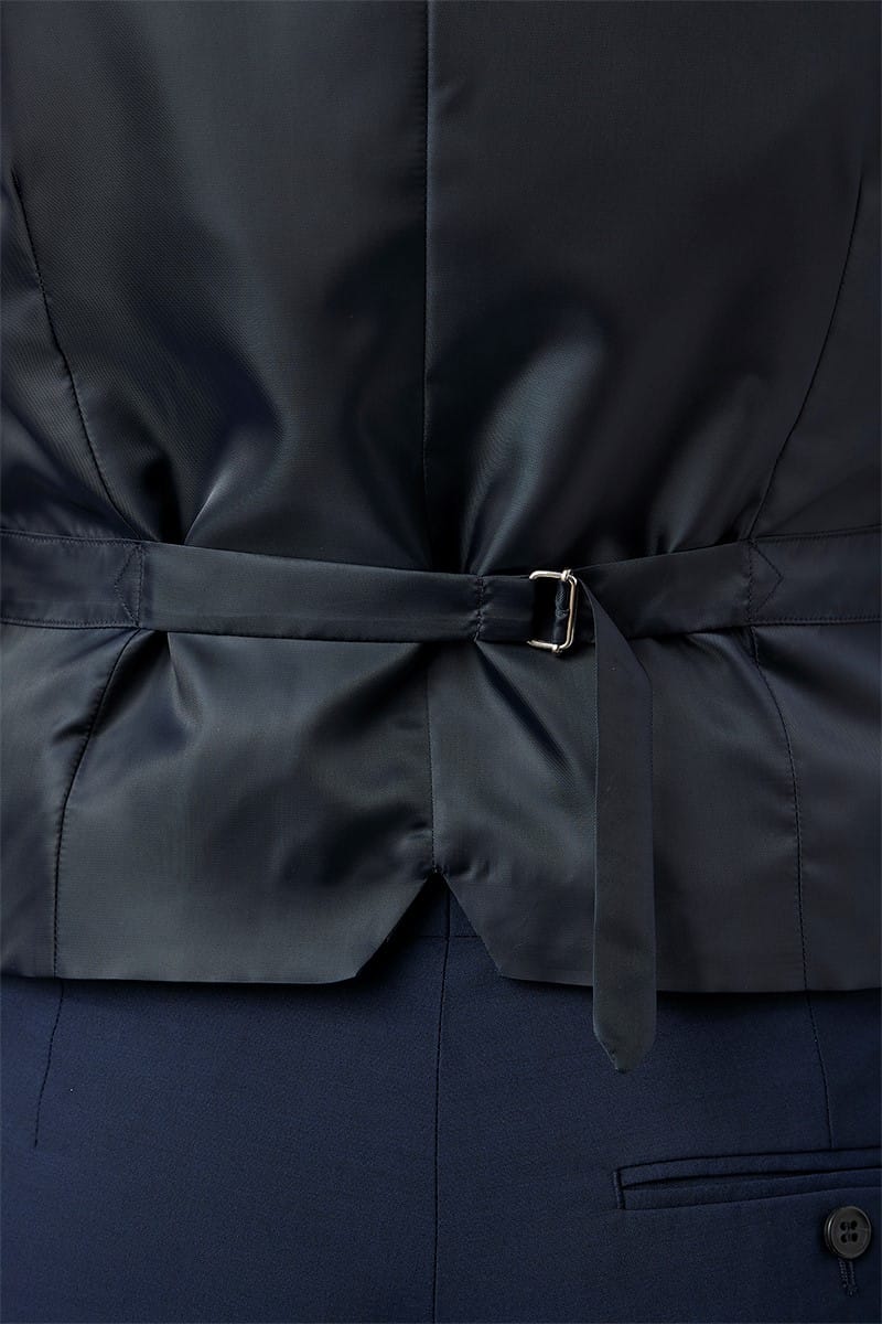 Close-up of a navy blue coat with a belt and button details.