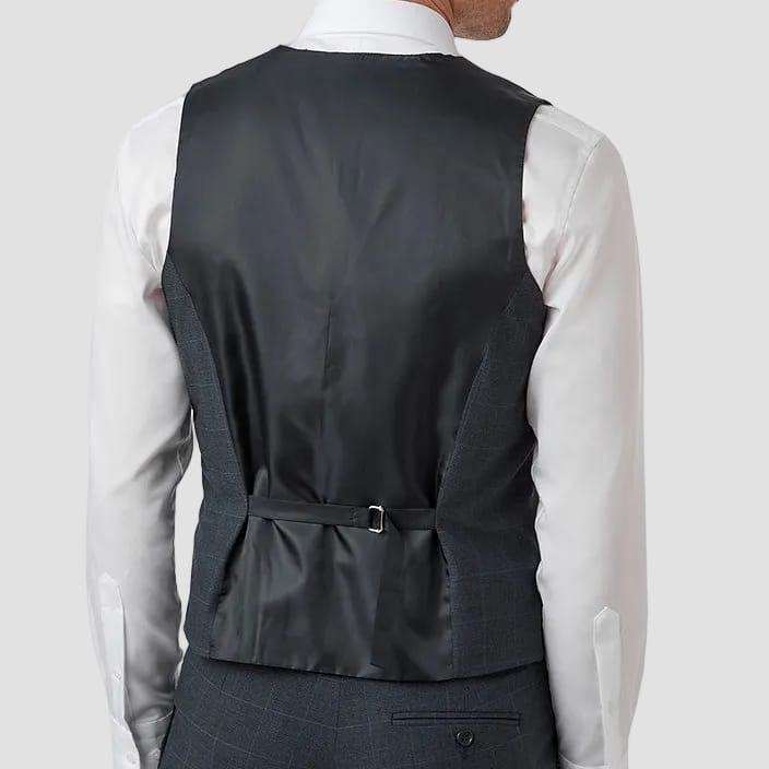 Man wearing a gray vest over a white shirt on a white background