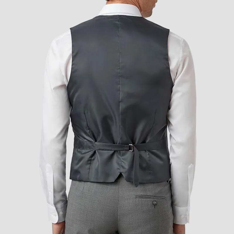 Man wearing a gray vest over a white shirt and gray pants on a white background