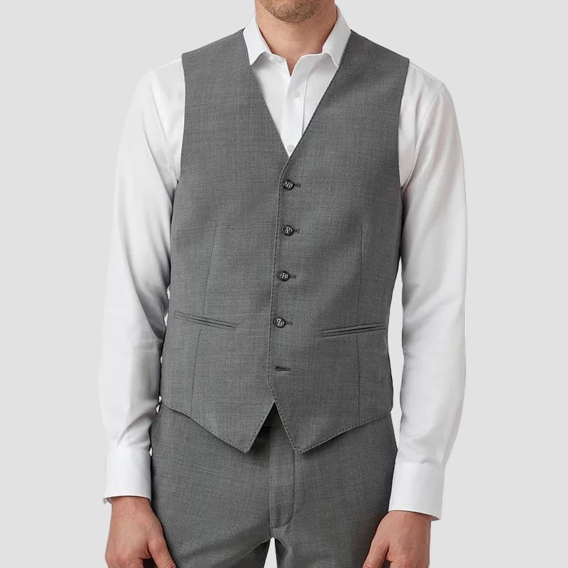 Man wearing a gray suit vest over a white shirt on a white background