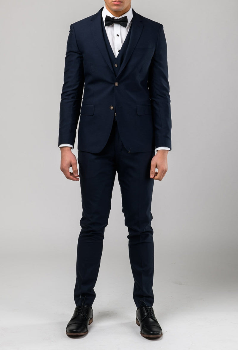 a front view of the Aston slim fit colton trouser in navy pure wool A0437162T as part of the c Colton suit styled with a white shirt and black bow tie