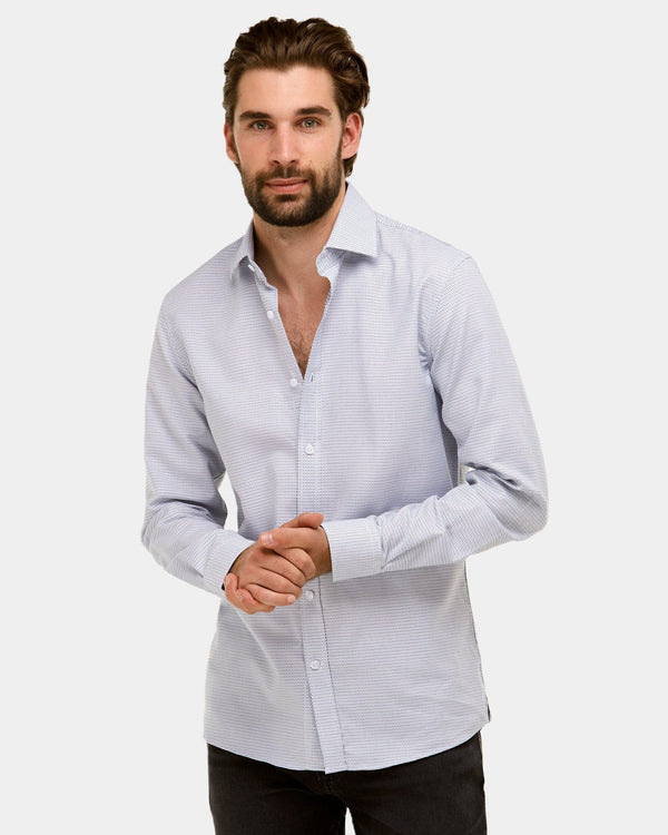 a model wears the brooksfield small dot mens dress shirt in white with blue dots