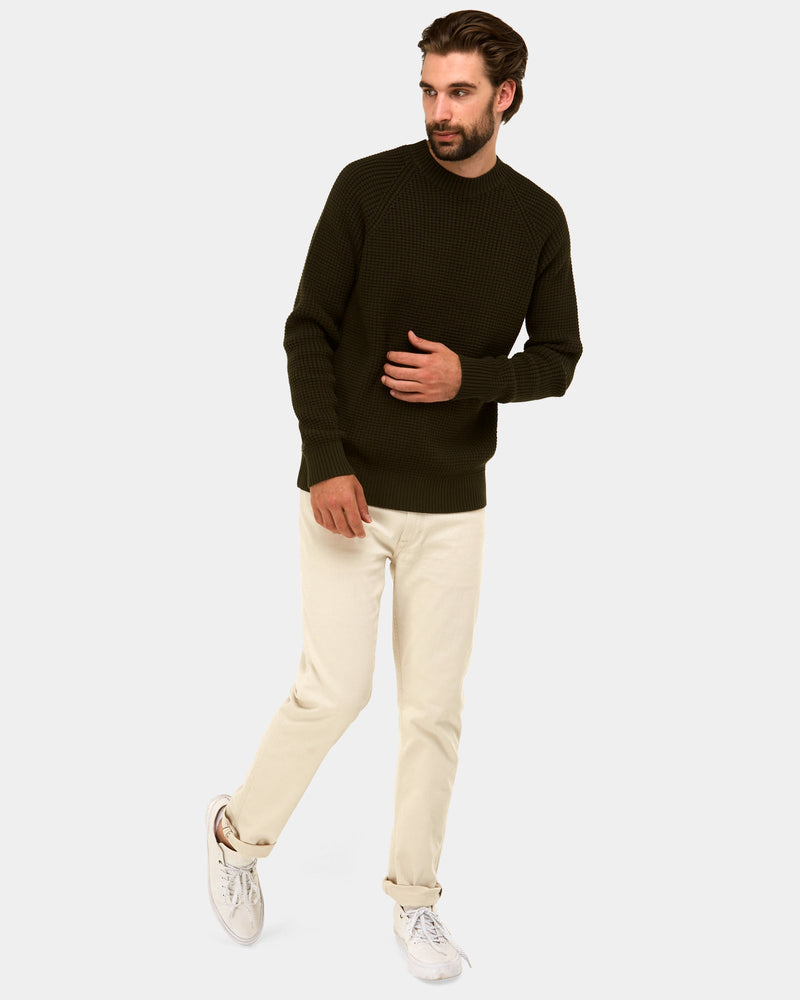 a mens knitted sweater with a beige chino pant and white sneakers