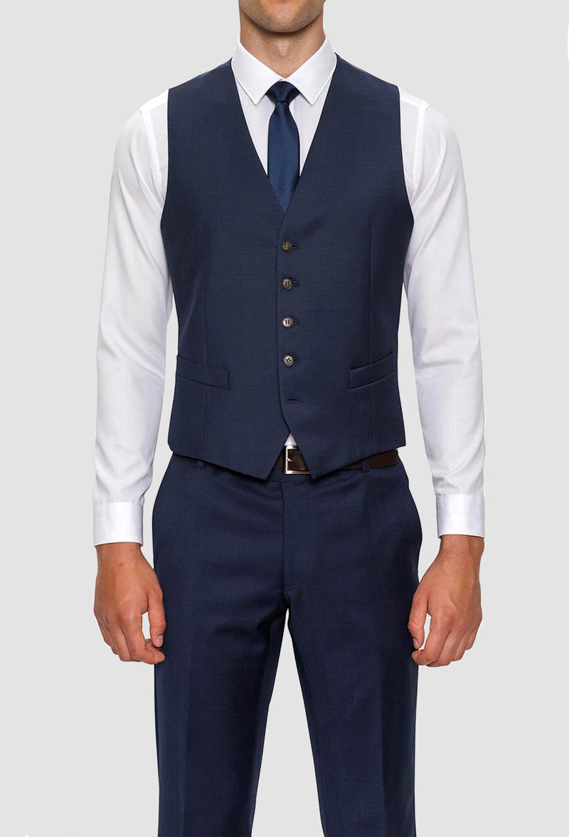 A front on view of a model wearing A model wears the Gibson slim fit mighty vest in navy pure wool with a white shirt and navy tie