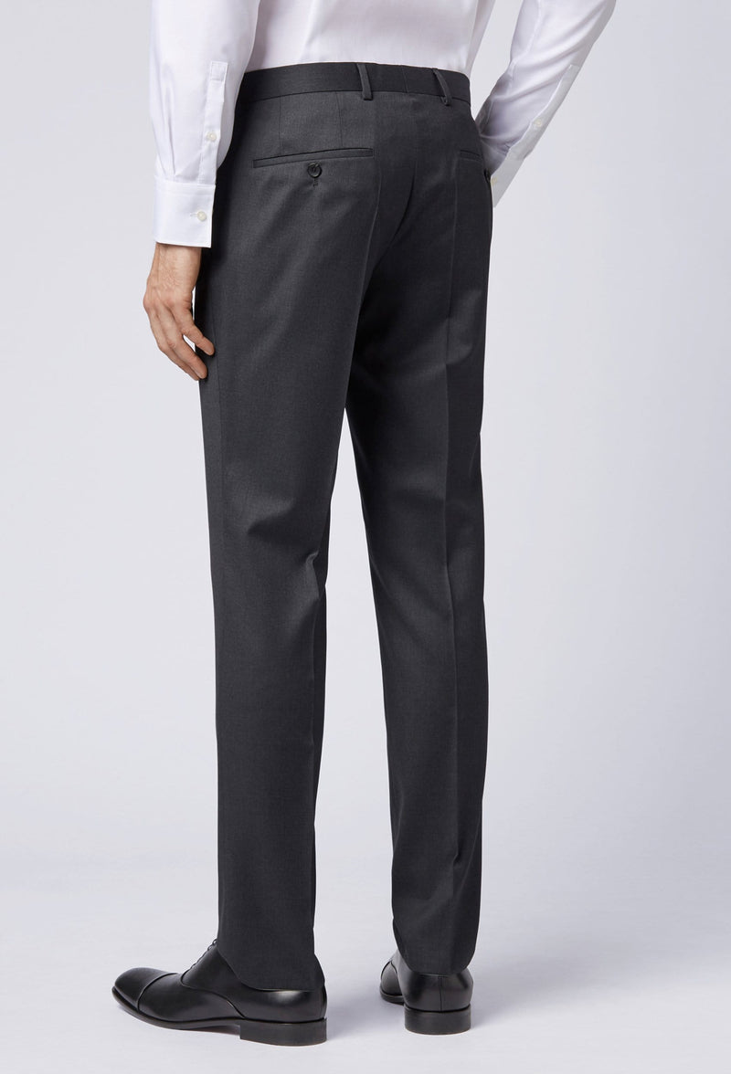 A reverse view of a man standing in the Hugo Boss classic fit johnstons suit trouser in dark grey 