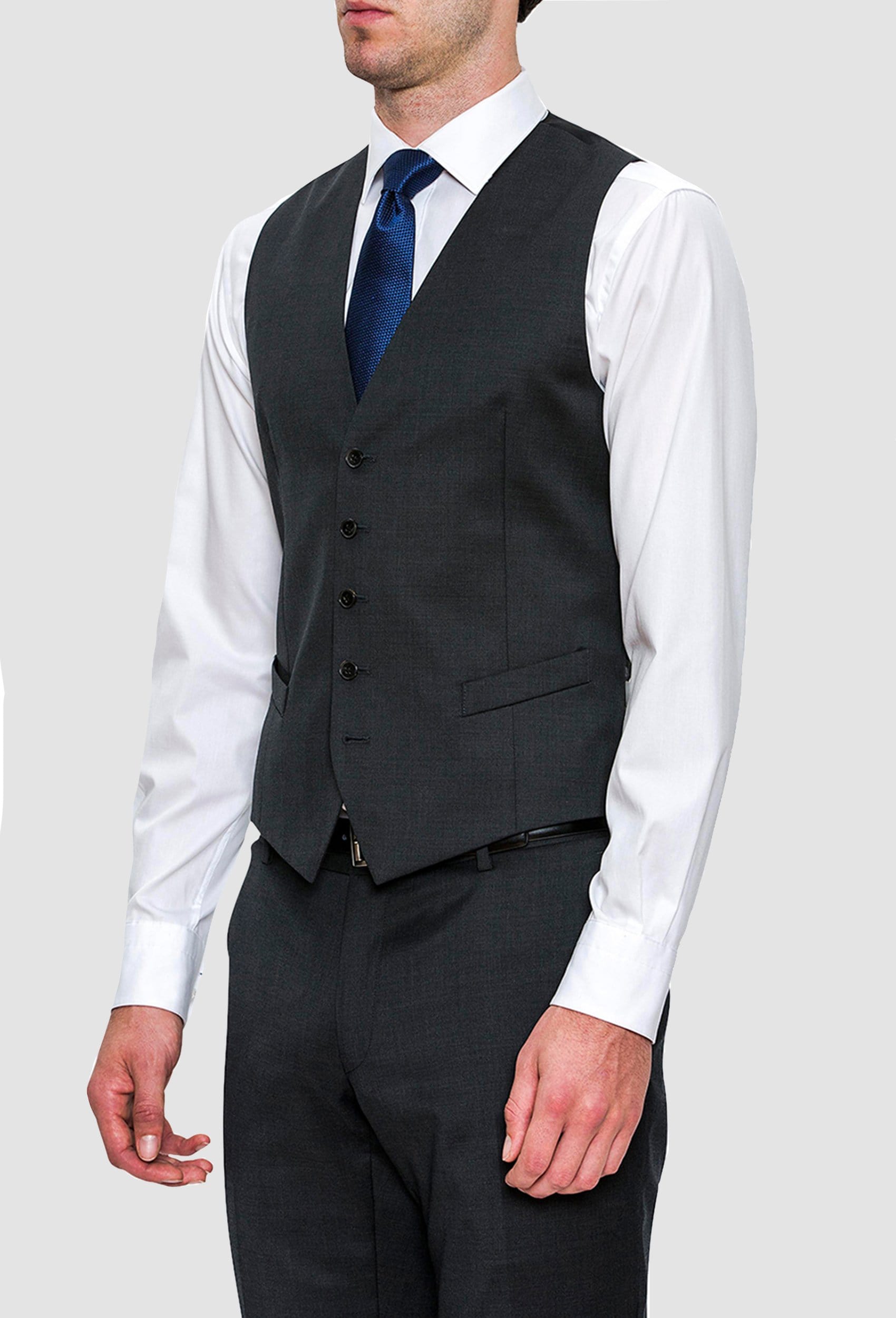 a side view of a model wearing the Joe Black slim fit mail vest in charcoal pure wool FCZ027 layered over a white shirt with a blue tie