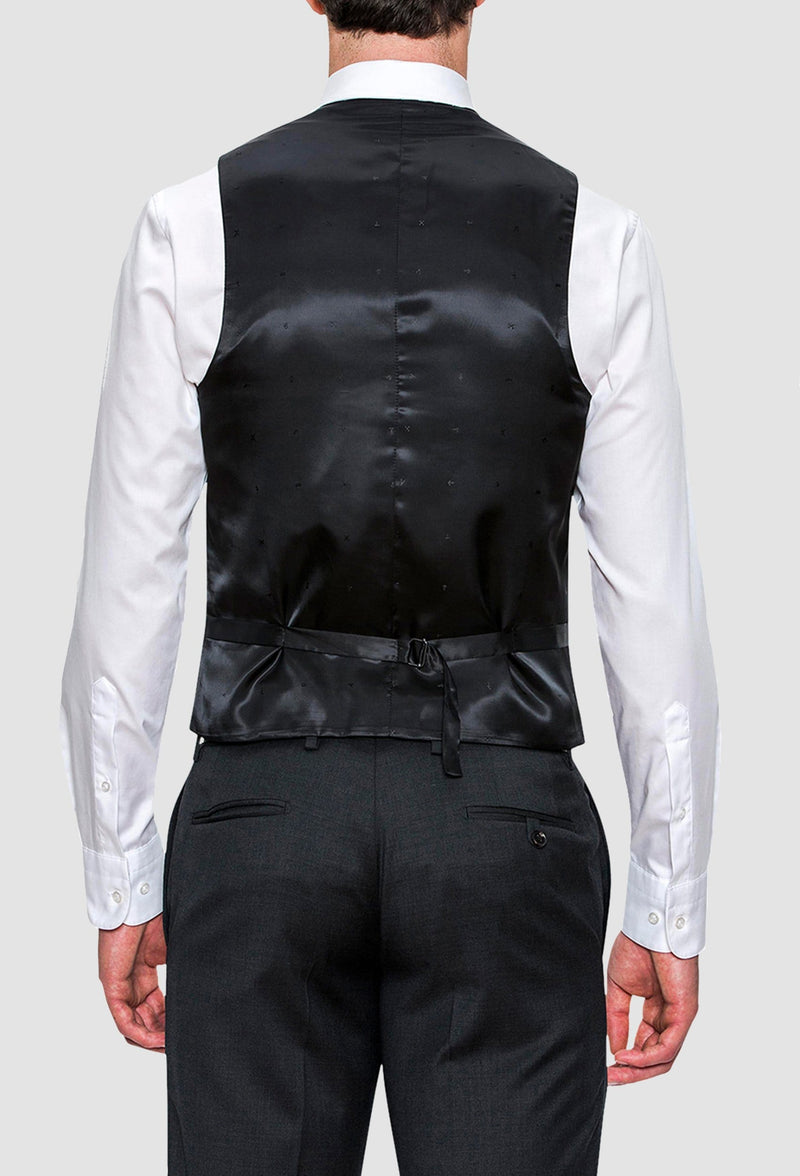 the back view of the Joe Black slim fit mail vest in charcoal pure wool layered over a navy trouser and white shirt 