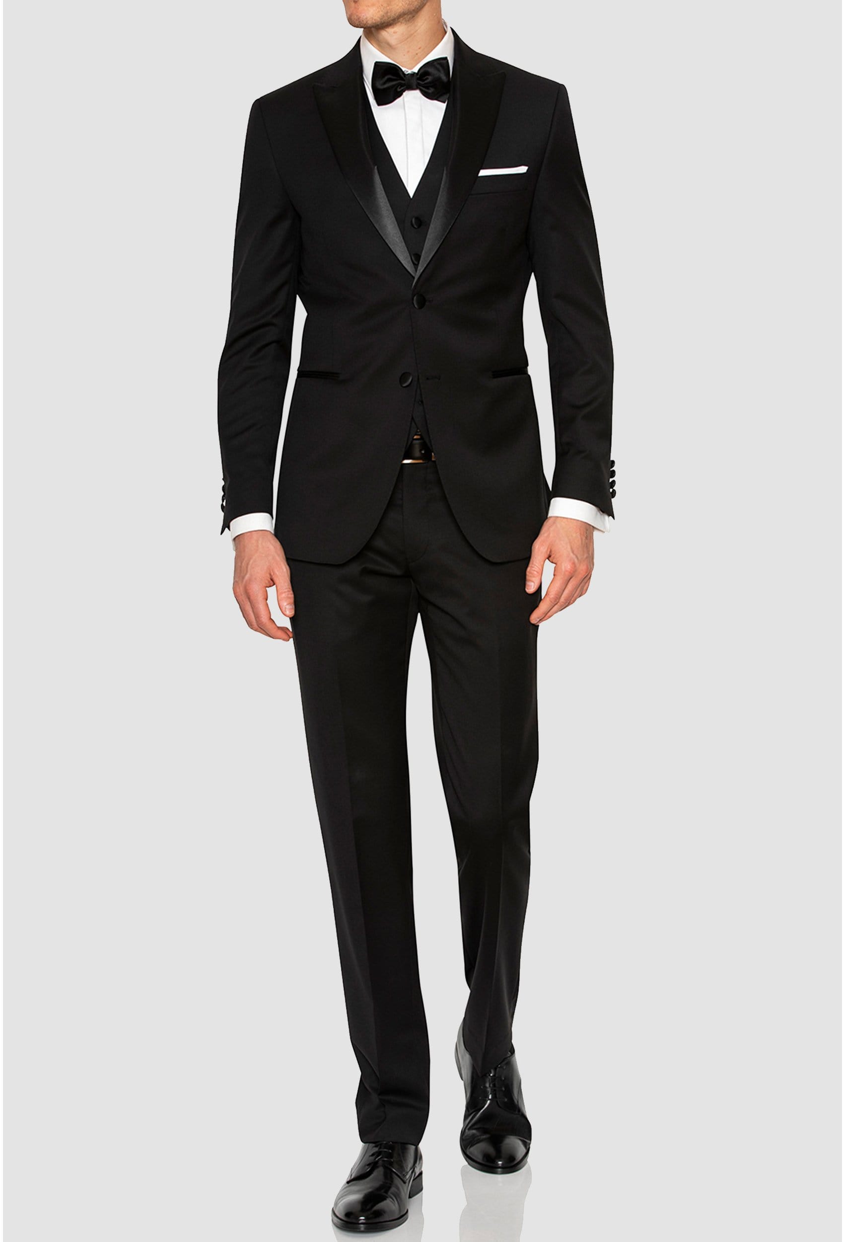 a model wears the Joe Black slim fit sloane evening suit in black pure wool F6447 styled with a white shirt and black bow tie