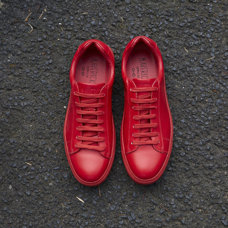 a pair of bright red mens sneakers in a red leather