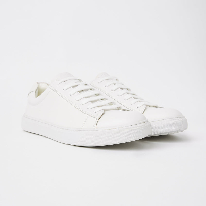 a pair of mens white leather dress sneakers 