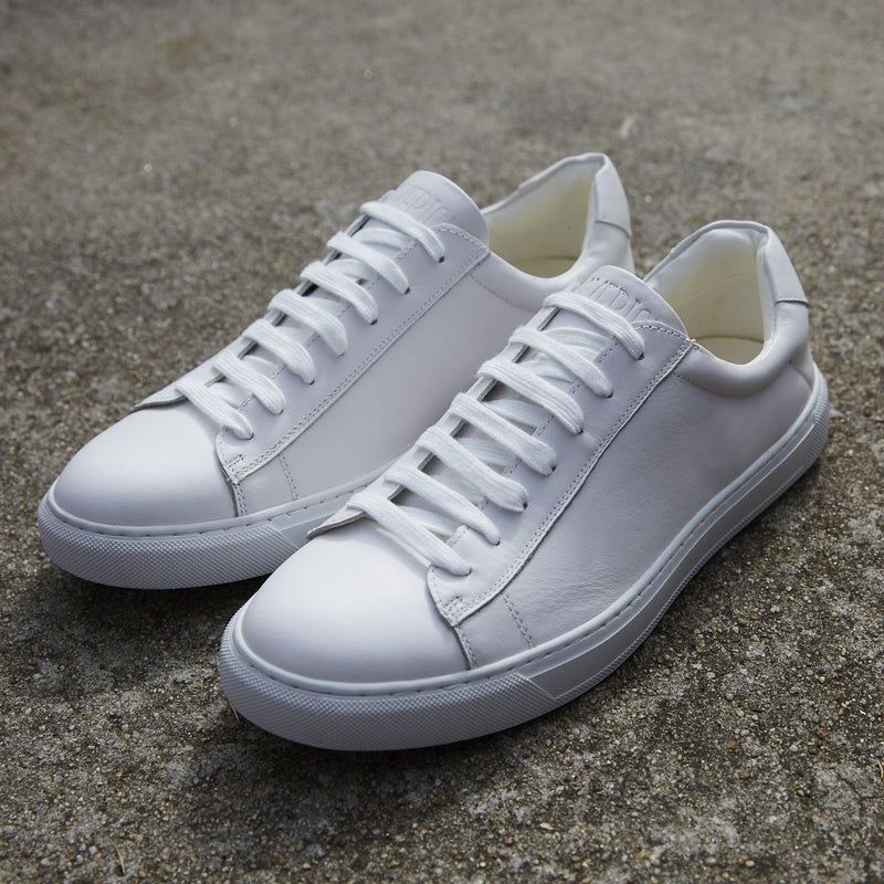 a pair of white mens sneakers with white laces
