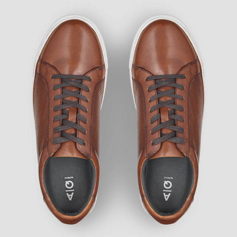 the round toe and dark brown laces of the aquila smith mens leather sneaker in tan