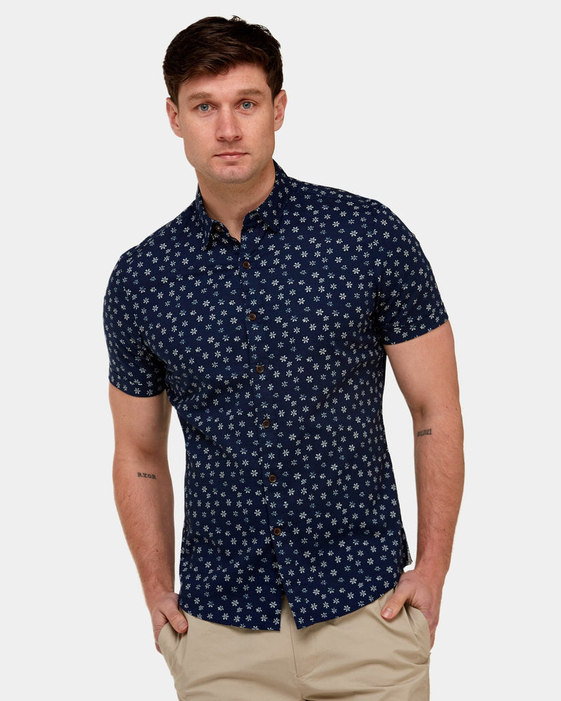 a navy blue mens short sleeve shirt with small white floral print all over