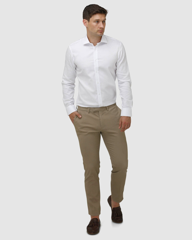 a man wears a brooksfield white shirt with tan chino pants