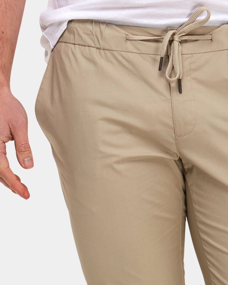 the elastic waist band and drawcord of the brooksfield mens chino pants in beige