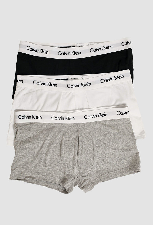 the three pack of Calvin Klein briefs is layered on top of each other showing each colour black grey and white and the detailed logo waistbands