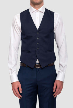 A front on view of a model wearing the Cambridge classic fit beaumont vest in dark blue navy pure wool F2800 styled with the navy interceptor trouser and a white shirt