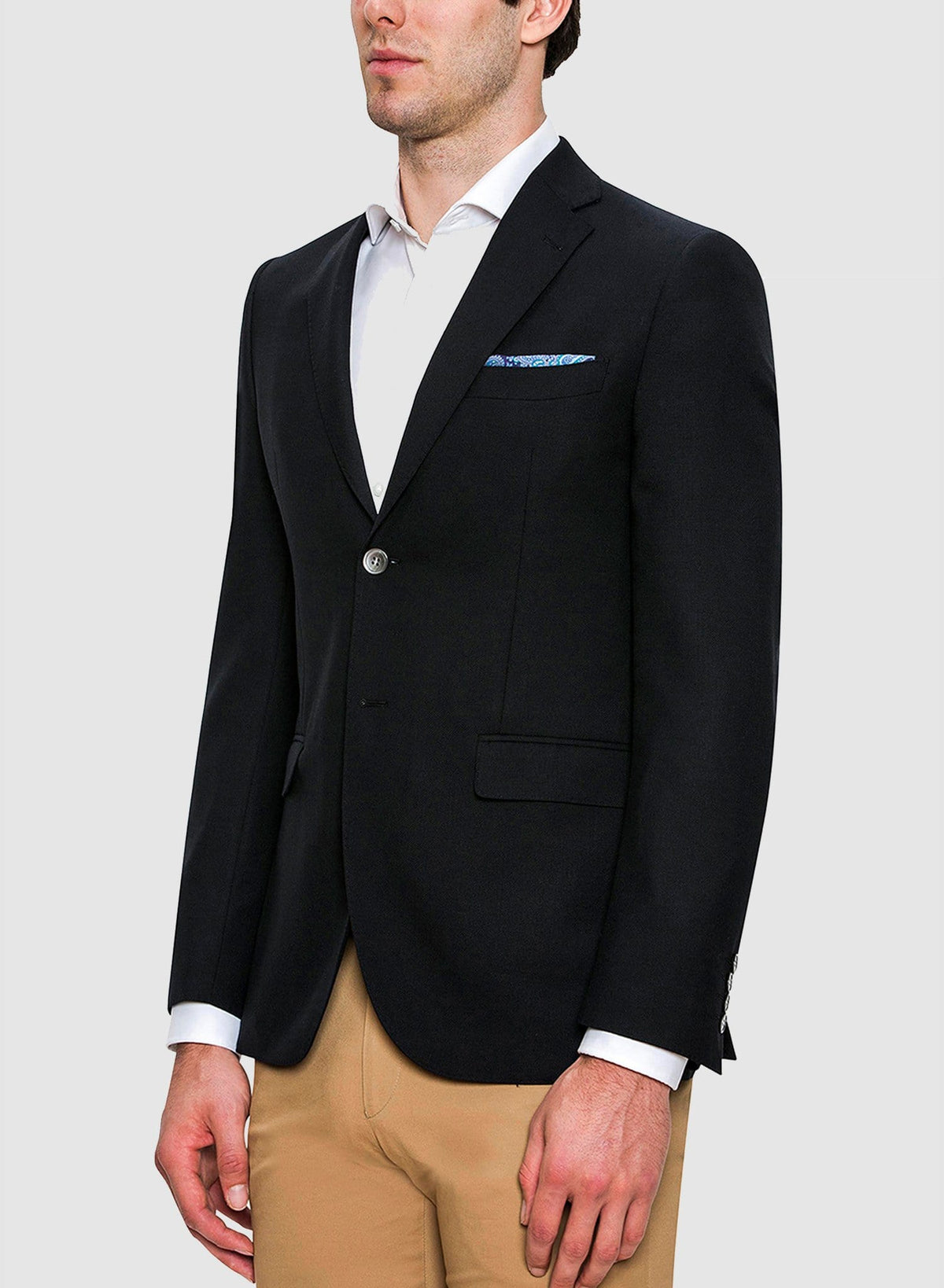 a model wears the cambridge classic fit unit sports jacket in navy with a white shirt and beige chino FCD012 the ultimate travel jacket