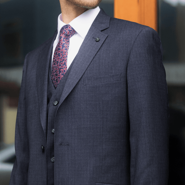 man wears a three piece navy blue suit by christian brookes