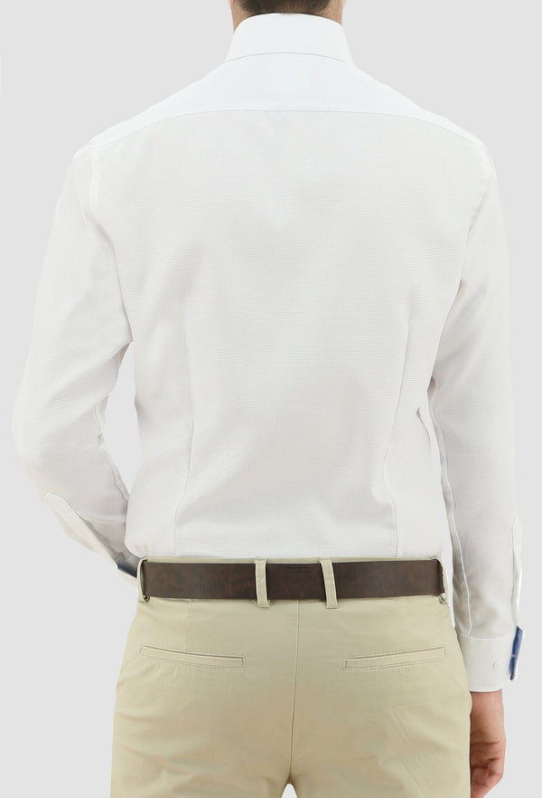 a model faces the back revealing the darted back on the daniel hechter slim fit jacques mens business shirt in white pure cotton styled with a chocolate brown belt and sand coloured trousers