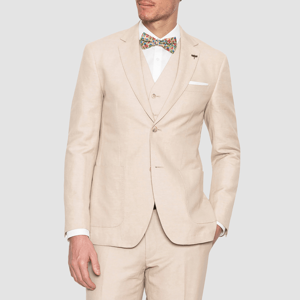 a linen jacket vest and trouser in sand colour with a white shirt and floral bowtie